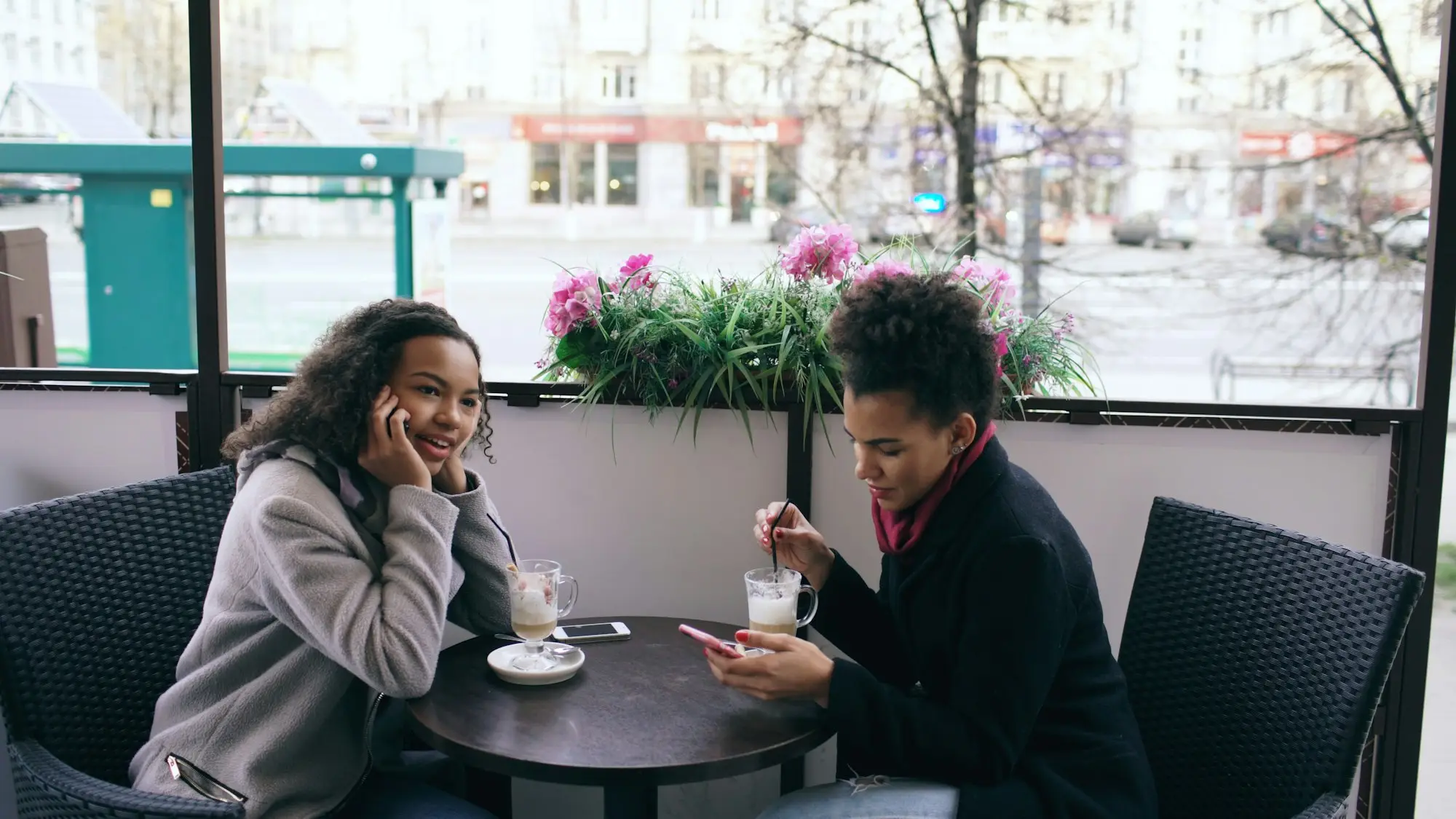 Two women talking at an outdoor café table